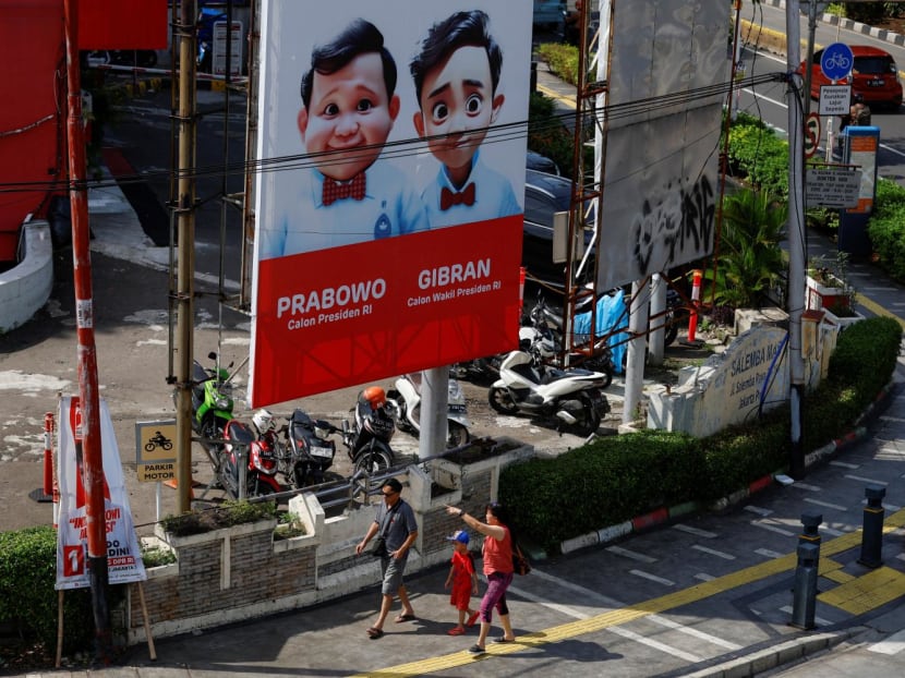 People walk past a billboard promoting Indonesia's Defence Minister and Presidential candidate Prabowo Subianto and his running mate Gibran Rakabuming Raka ahead of the upcoming general election in Jakarta, Indonesia on Jan 12, 2024. 