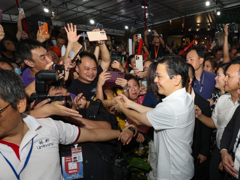 A jubilant crowd of residents greeting and shaking hands with Prime Minister Lawrence Wong at a viewing party in Yew Tee on May 15, 2024. 