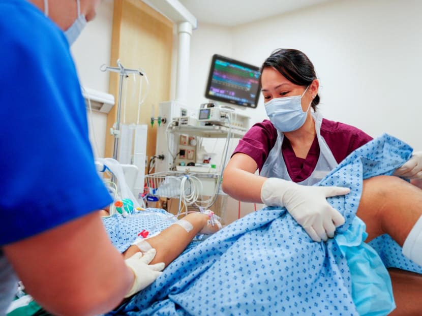 Ms Kwan Peijun, a senior principal physiotherapist, working with a team of nurses to tend to a patient who was treated at the National University Centre for Trauma.