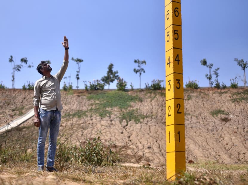 This photograph taken on Jan 29, 2024 shows mechanical engineer Anand Malligavad, known as "lake man" for his campaign to bring scores of lakes back to life, near a staff gauge used to measure water levels installed at the arid Doddathogur lake in Bengaluru.