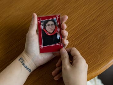 Mrs Liping Pauwels holding a photo of her daughter Elisabeth who died of suicide in 2019. She got a tattoo of her daughter’s name — in the teenager's handwriting — on her wrist six months after her daughter's death.